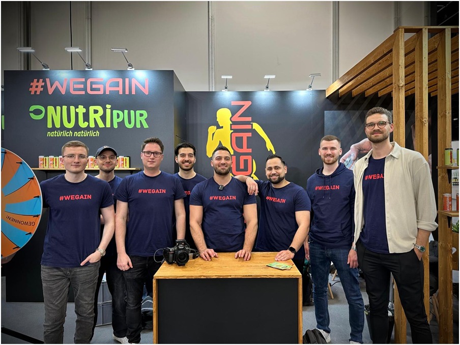 WEGAIN Team am Messestand mit #WEGAIN T-Shirts